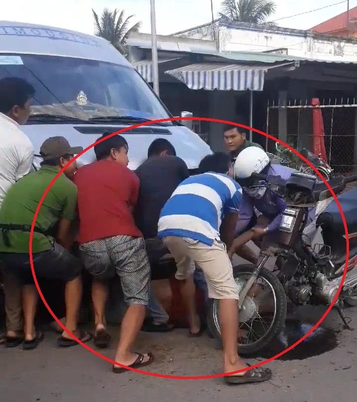 Nguoi dan hop suc nang oto cuu lai xe may ket duoi gam hinh anh