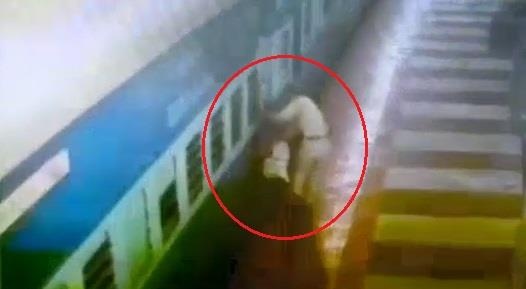 Canh sat cuu nguoi dan ong ket duoi doan tau dang chay hinh anh