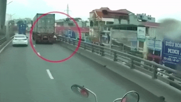 Di vao duong cam, xe may may man thoat chet duoi banh xe container hinh anh