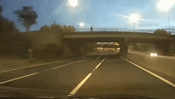 Nguoi dan ong nem gach trung oto dang chay tren cao toc hinh anh