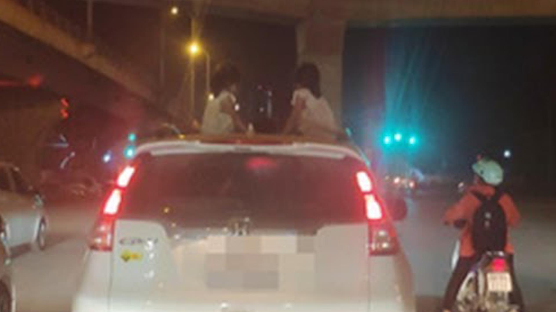 2 be gai ngoi noc oto dang chay hinh anh