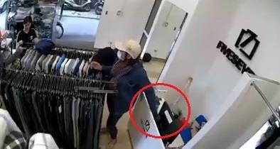 Nguoi phu nu trom dien thoai trong shop thoi trang o Ha Noi hinh anh