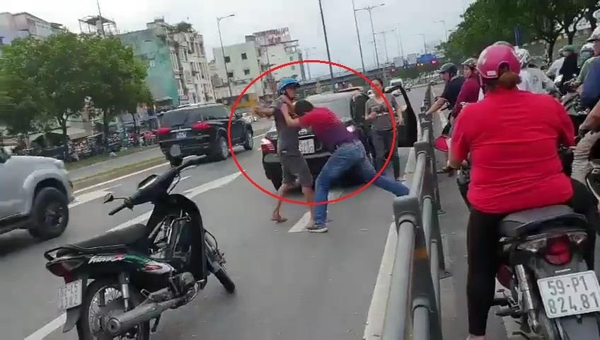 Xe may di vao lan oto roi danh nhau voi tai xe o TP.HCM hinh anh