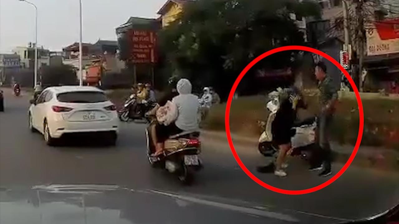 Nguoi dan ong thang tay danh phu nu mang bau giua duong hinh anh