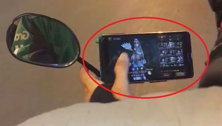 Xe om cong nghe vua cho khach vua choi game tren duong hinh anh