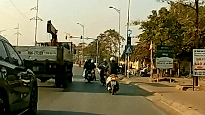 Nguoi phu nu di xe may nga vao banh xe tai khi doi den do hinh anh