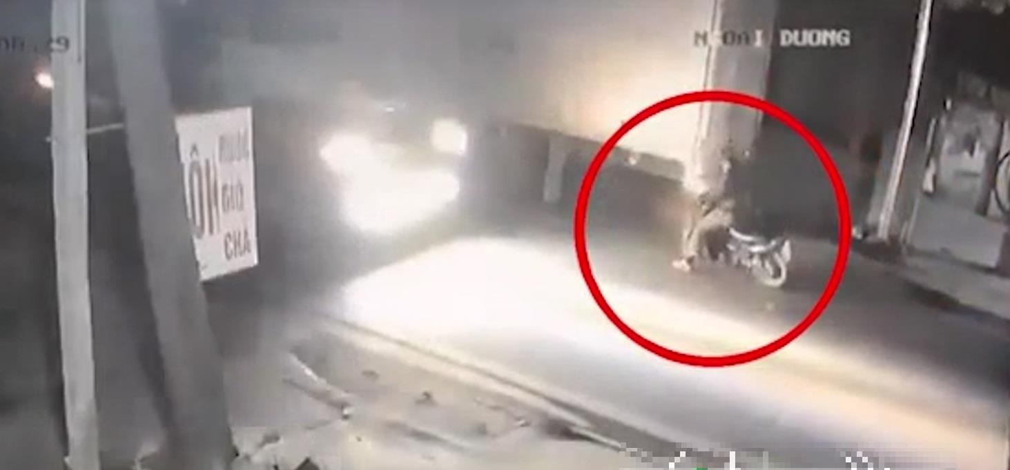 Tai xe xe may dam vao duoi xe tai nga ra duong, bi container can trung hinh anh