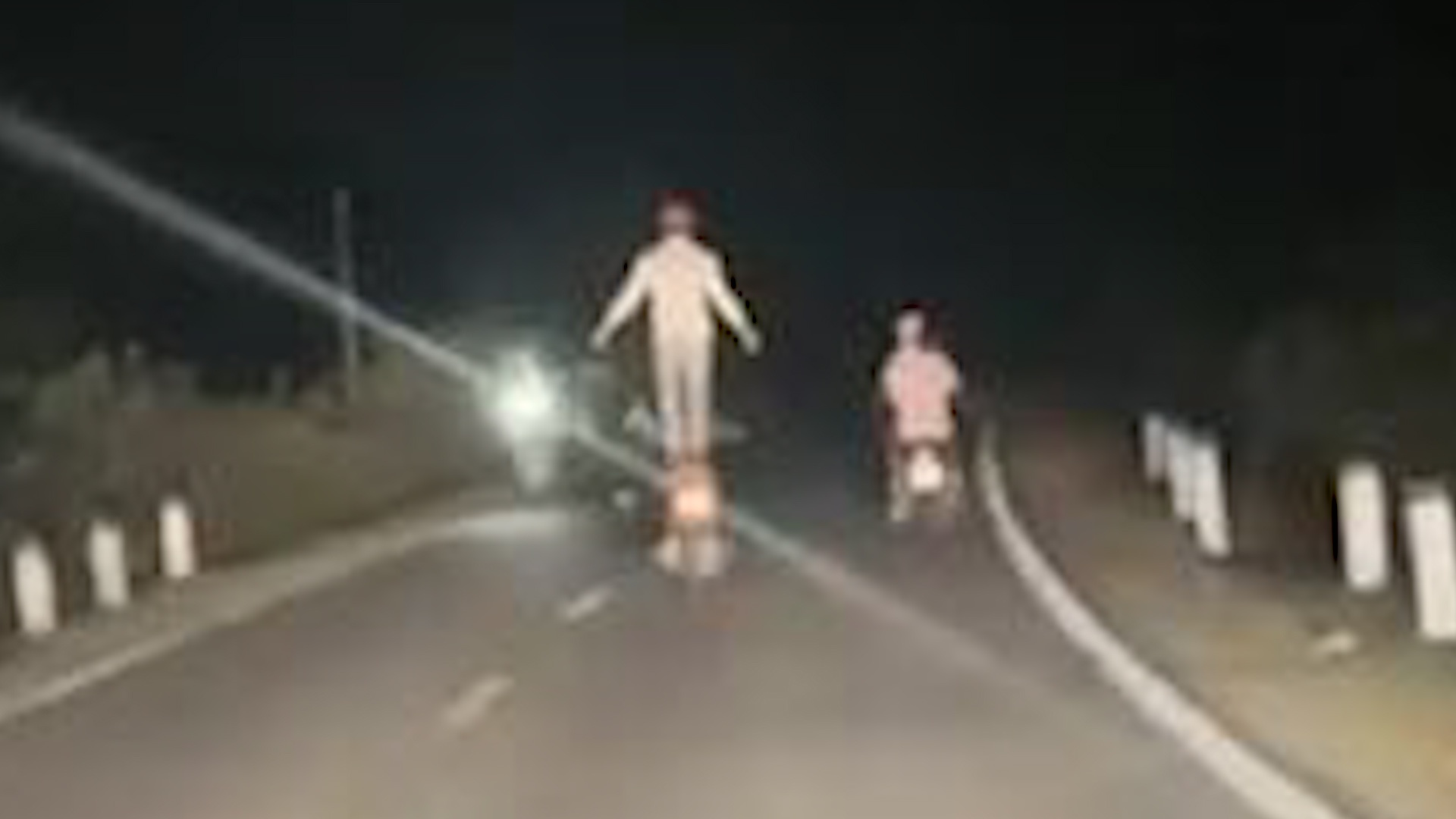 Nguoi dan ong lieu linh dung tren xe may chay trong dem hinh anh