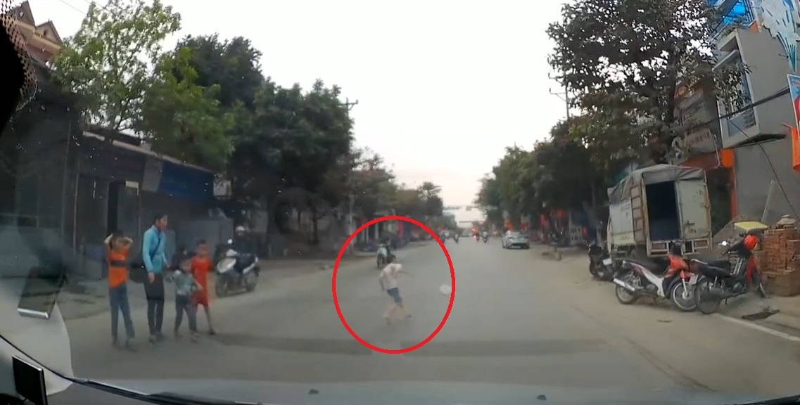 Be trai bat ngo lao ra duong ngay truoc dau oto hinh anh