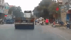 Nu sinh di xe dap dien nga ra duong, suyt bi container chen qua hinh anh