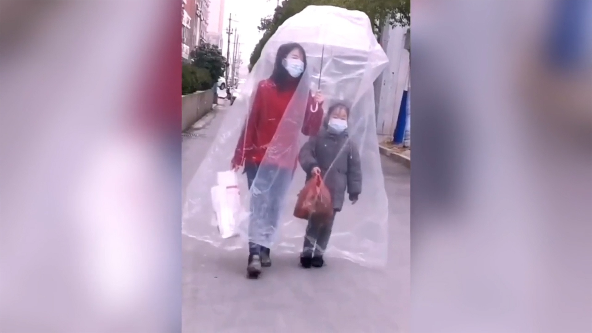 2 me con deo khau trang va trum tui nhua kin mit chong virus corona hinh anh