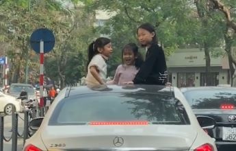 Ba dua tre dua nghich tren cua so troi khi oto dang di chuyen hinh anh