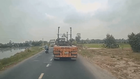 Co vuot container, cap vo chong di xe may nga truoc dau xe tai hinh anh