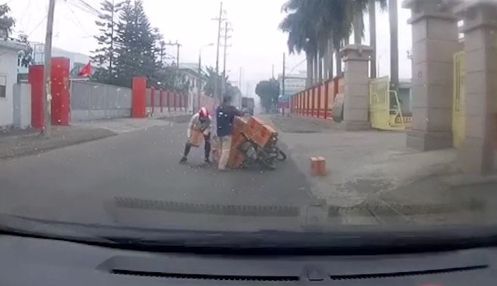 Tai xe giup nam thanh nien bi lat xe cho do giua duong hinh anh