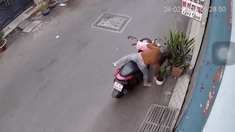 Nu tai xe nga nhao khi trom chau hoa ven duong hinh anh