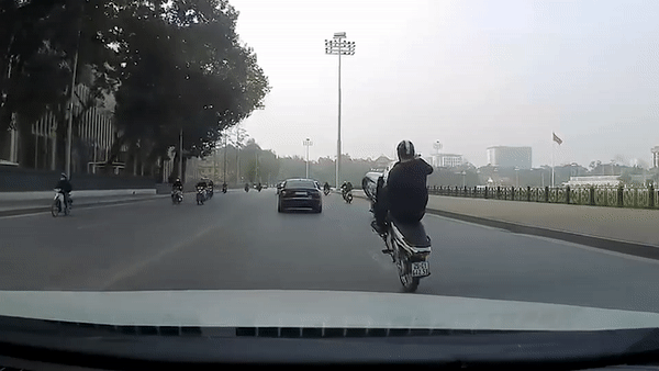 Thanh nien boc dau xe may ngay truoc oto hinh anh