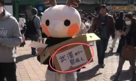 Co gai Trung Quoc phat khau trang mien phi tren duong pho Nhat Ban hinh anh