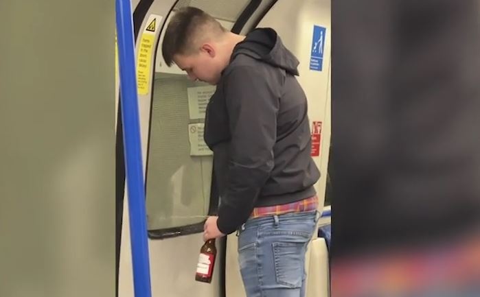 Chang trai ngang nhieu tieu tien vao chai bia tren tau dien ngam hinh anh