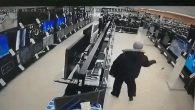 Nguoi dan ong dung bua dap hang loat tivi trong cua hang dien may hinh anh