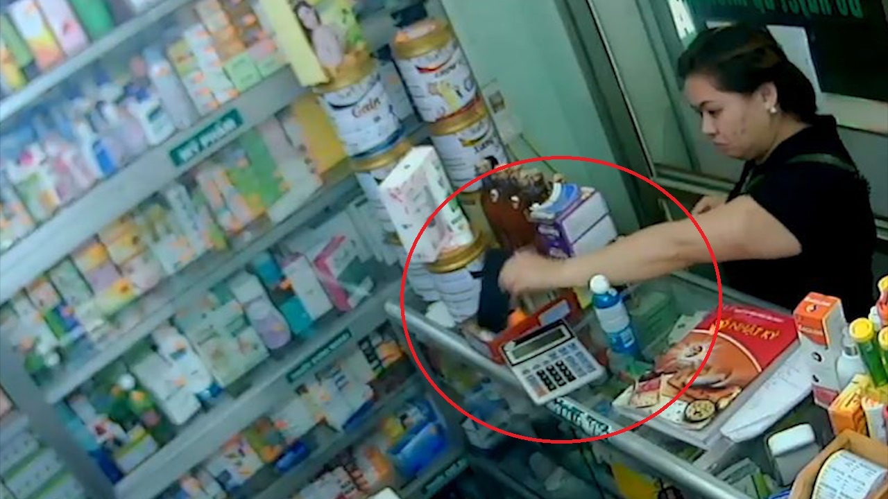 Gia vo mua thuoc, nguoi phu nu cuom dien thoai cua nhan vien hinh anh