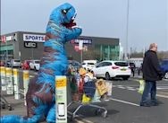 Nguoi dan mac trang phuc T-rex di sieu thi trong mua dich hinh anh