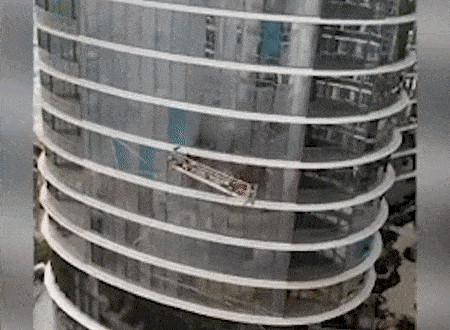 Gio manh thoi 2 cong nhan lau cua so xoay 180 do tren khong trung o My hinh anh