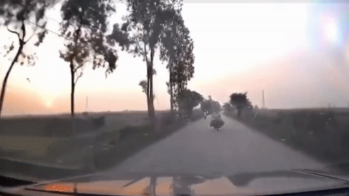 Nguoi phu nu lai xe may chay giua duong suyt dam vao oto hinh anh