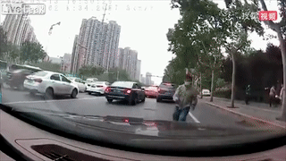 Nguoi dan ong tu trong via he lao ra duong, nhay len dau oto hinh anh