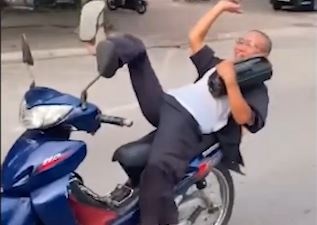 Nguoi dan ong nam ngua ra xe may chay tren duong hinh anh