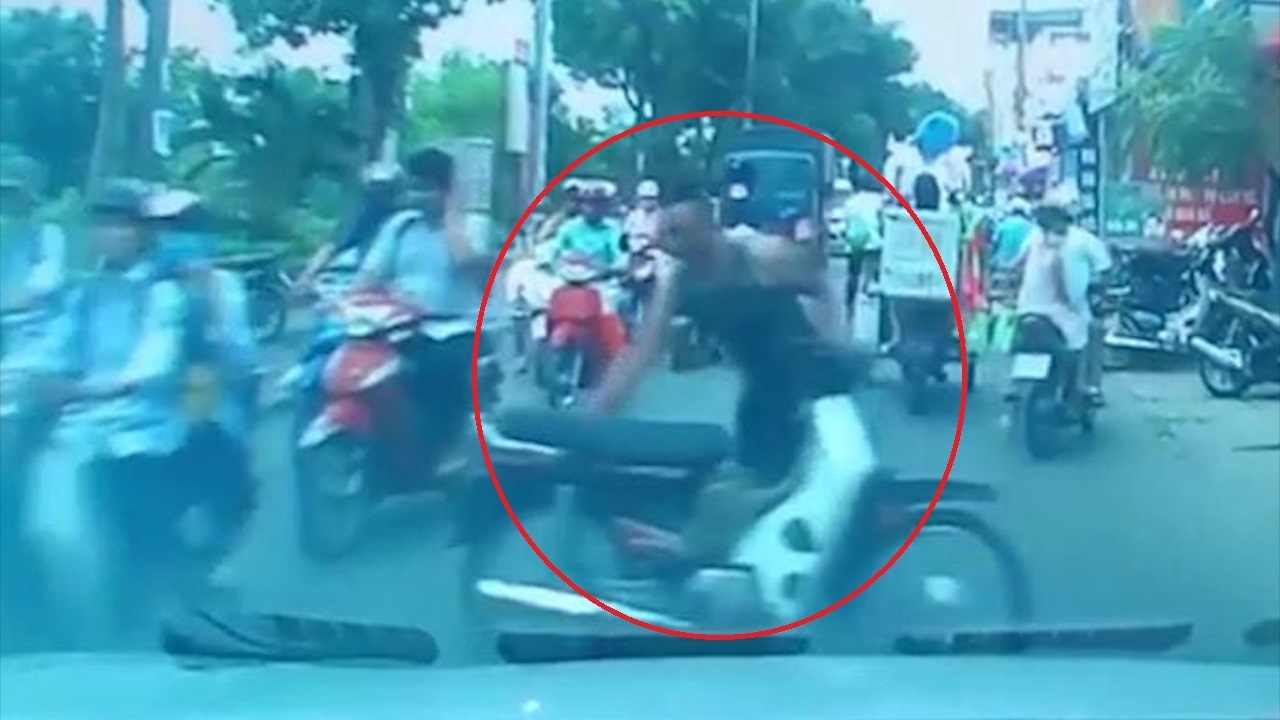 Nguoi dan ong dung xe may giua duong thach thuc tai xe oto hinh anh