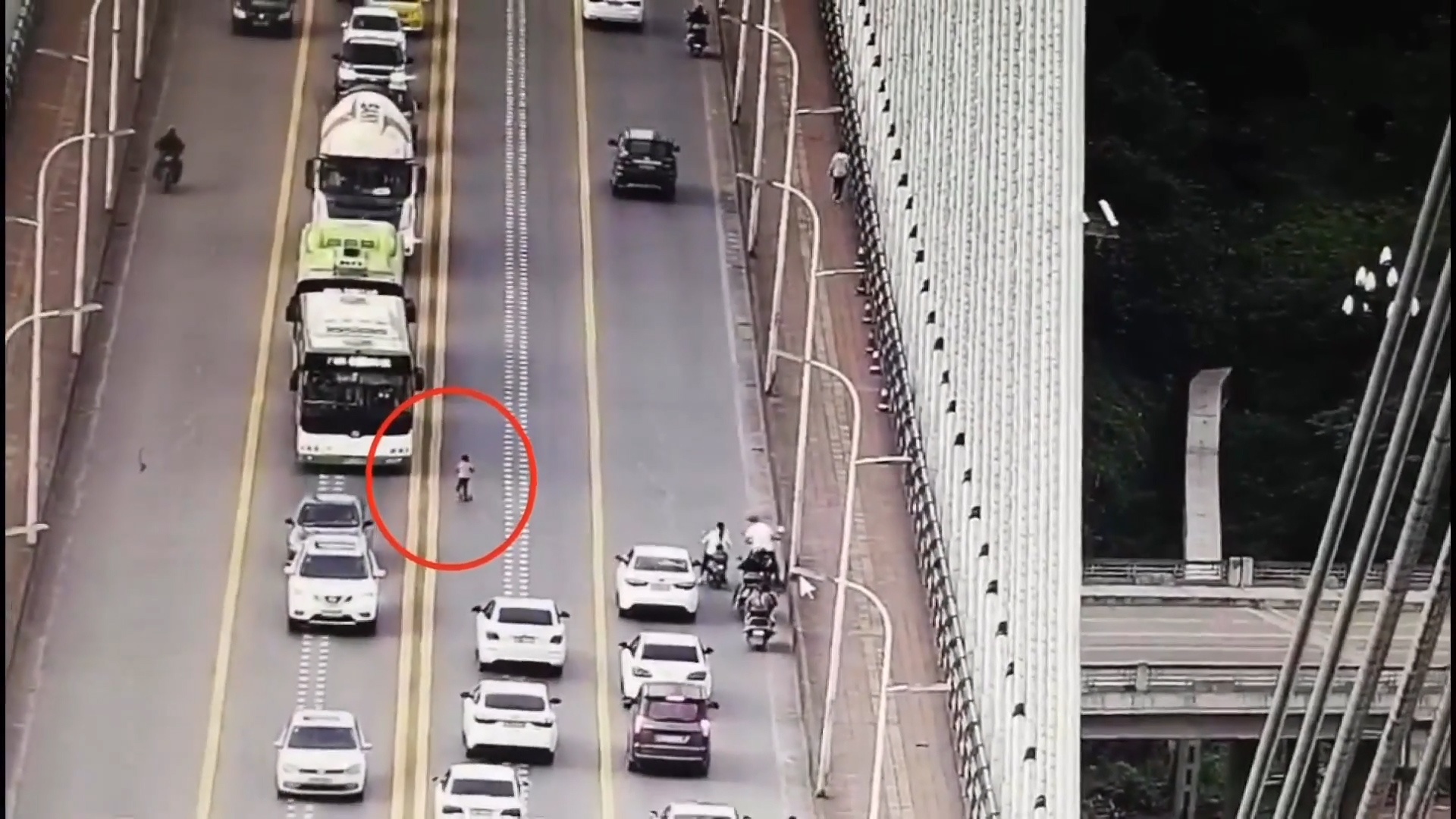 Be trai chay xe do choi tren cau dong duc phuong tien hinh anh