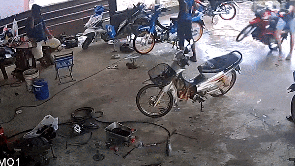 Hai thanh nien di xe may lao thang vao tiem sua xe o Thai Lan hinh anh