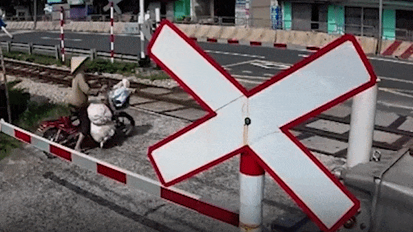 Co vuot duong ray, nguoi phu nu vut xe khi tau lao den hinh anh