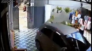 Nu tai xe lui oto dam tung cong nha lao ra duong hinh anh