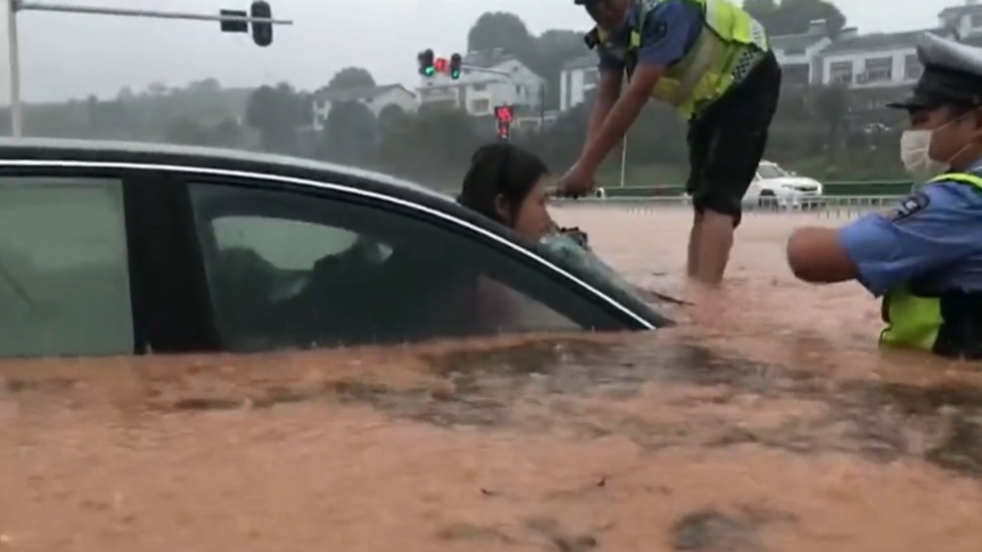 Canh sat giai cuu gia dinh trong oto bi mac ket giua lu o TQ hinh anh