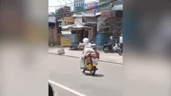 Nguoi phu nu vua nam vua lai xe tren duong o Binh Duong hinh anh