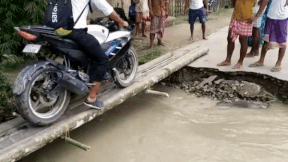 Biker nga xuong dong nuoc lu khi di qua cay cau hep hinh anh