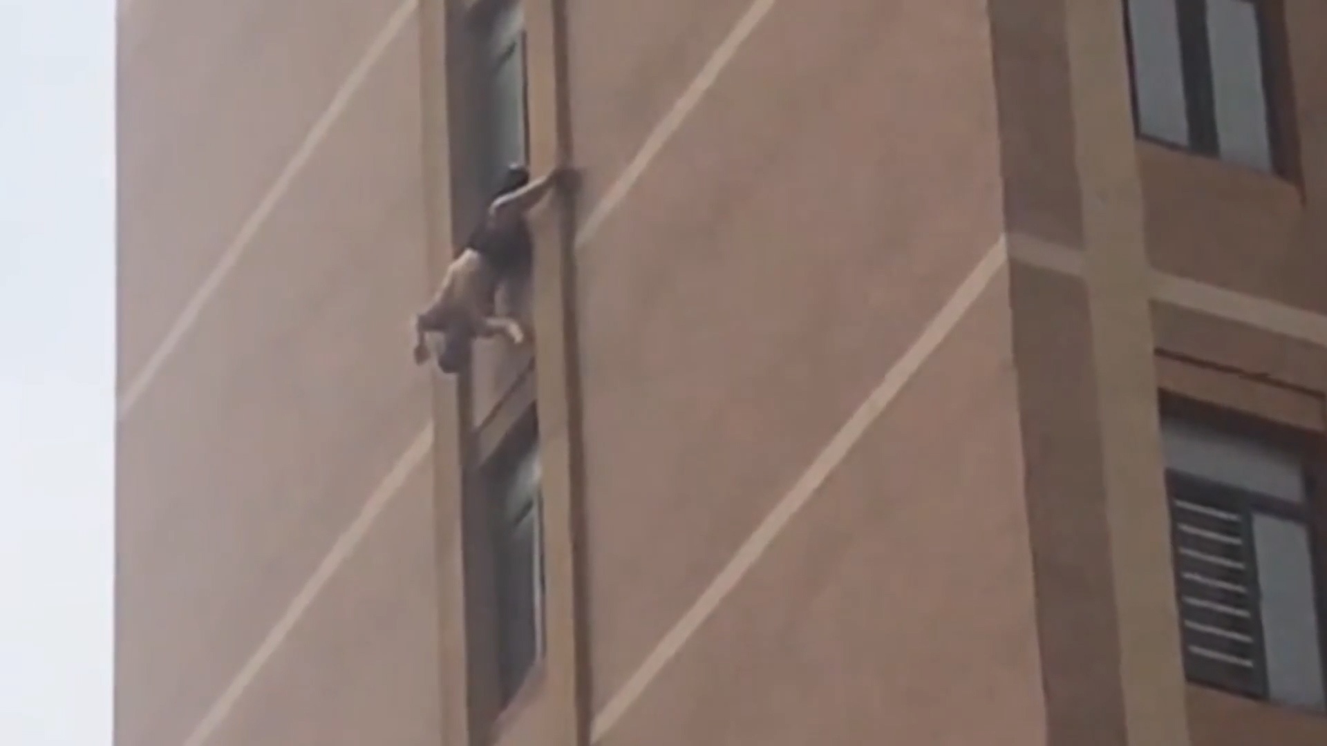 Giai cuu ong cu treo lo lung tu cua so can ho tang 10 o Trung Quoc hinh anh