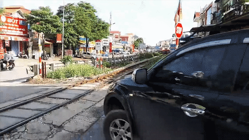 Xe ban tai vuot qua duong ray khi xe lua dang den hinh anh