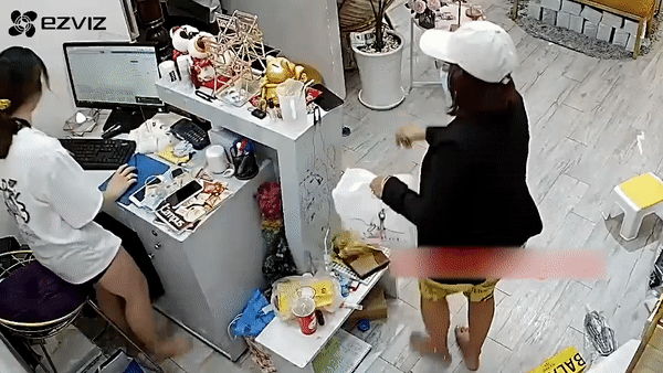 Nguoi phu nu trom dien thoai truoc mat nhan vien ban hang hinh anh