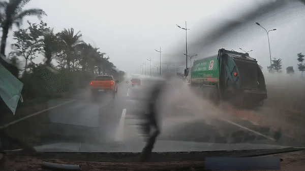 Xe moi truong phun nuoc trung oto chay phia sau hinh anh