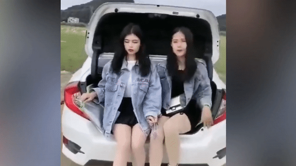 Hai co gai bi phat vi ngoi trong cop oto dang di chuyen hinh anh