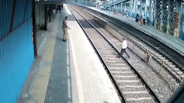 Nhat giay giua duong ray, nguoi dan ong suyt bi tau tong trung hinh anh