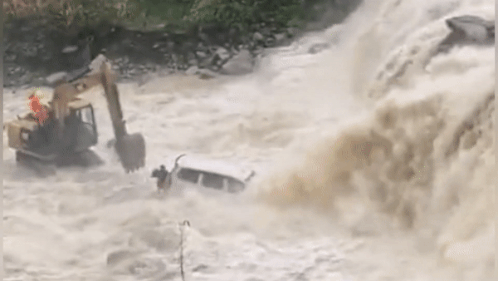 Xe may xuc giai cuu oto bi nuoc cuon troi hinh anh