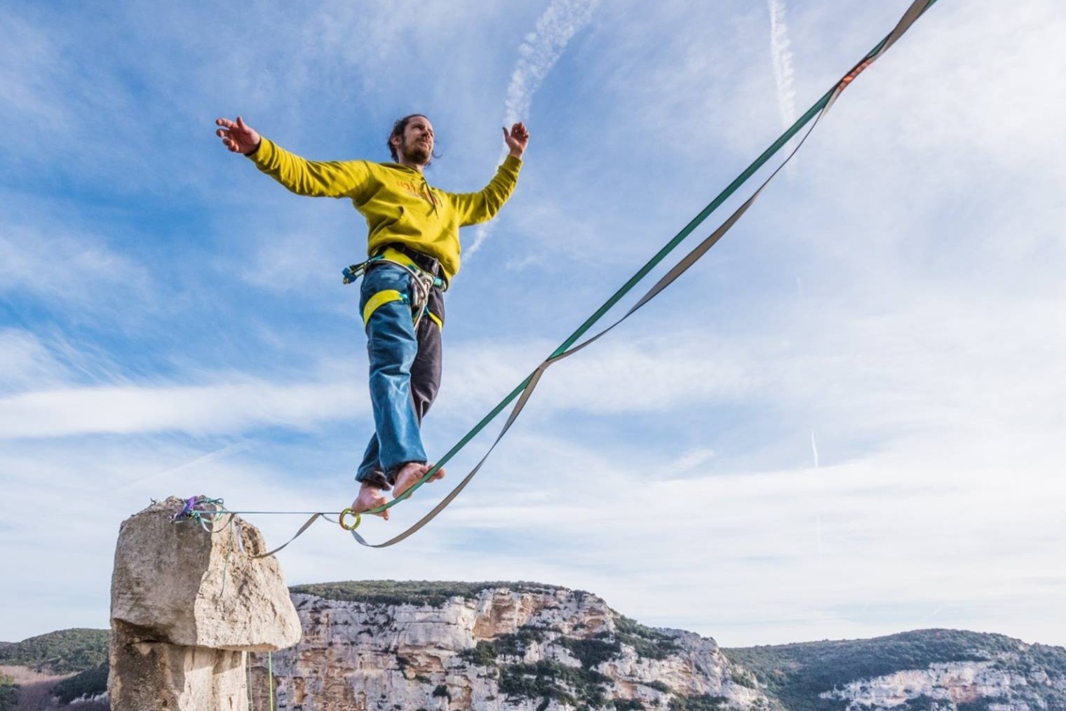 Chang trai mao hiem di tren day ben vach nui hinh anh