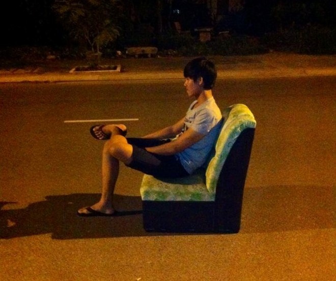 Chàng trai mang ghế salon ra giữa đường ngồi gây chú ý. Ảnh: NVCC.