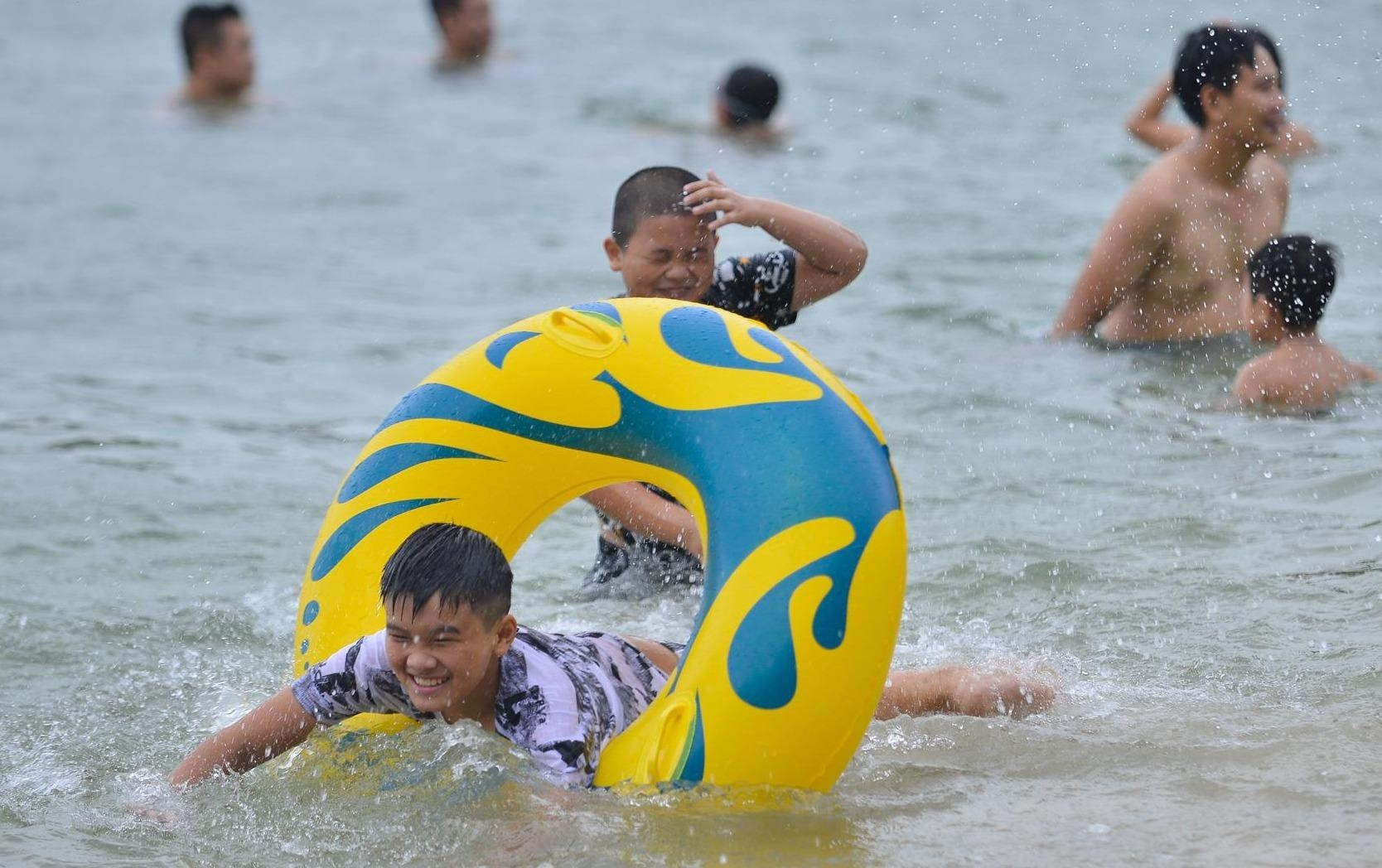 Nguoi dan lo doi pho bao, du khach thoai mai tam bien Cat Ba hinh anh