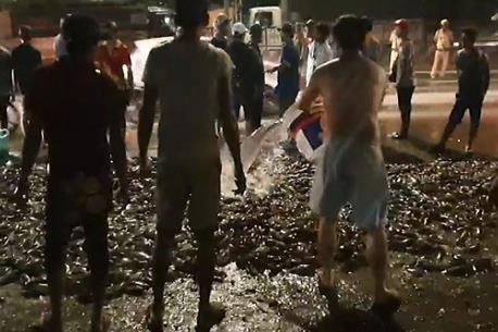 Xe tai lat giua quoc lo 1, dan thu gom hang tan ca ro giup tai xe hinh anh