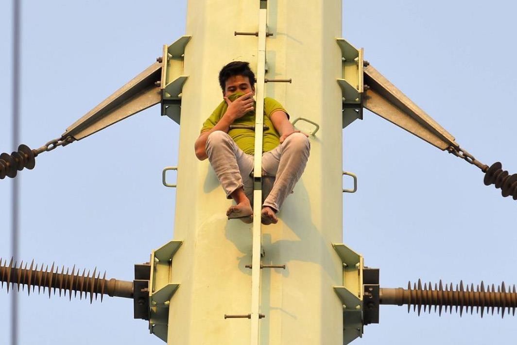 Nam thanh nien co thu tren cot dien cao the hinh anh