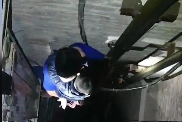 Be 4 tuoi va nguoi giai cuu cung mac ket duoi ho thang may hinh anh